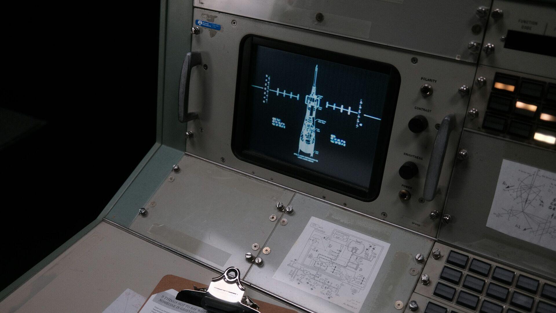 Engineers watching multiple screens showing orbital tracking data inside a satellite operations control room