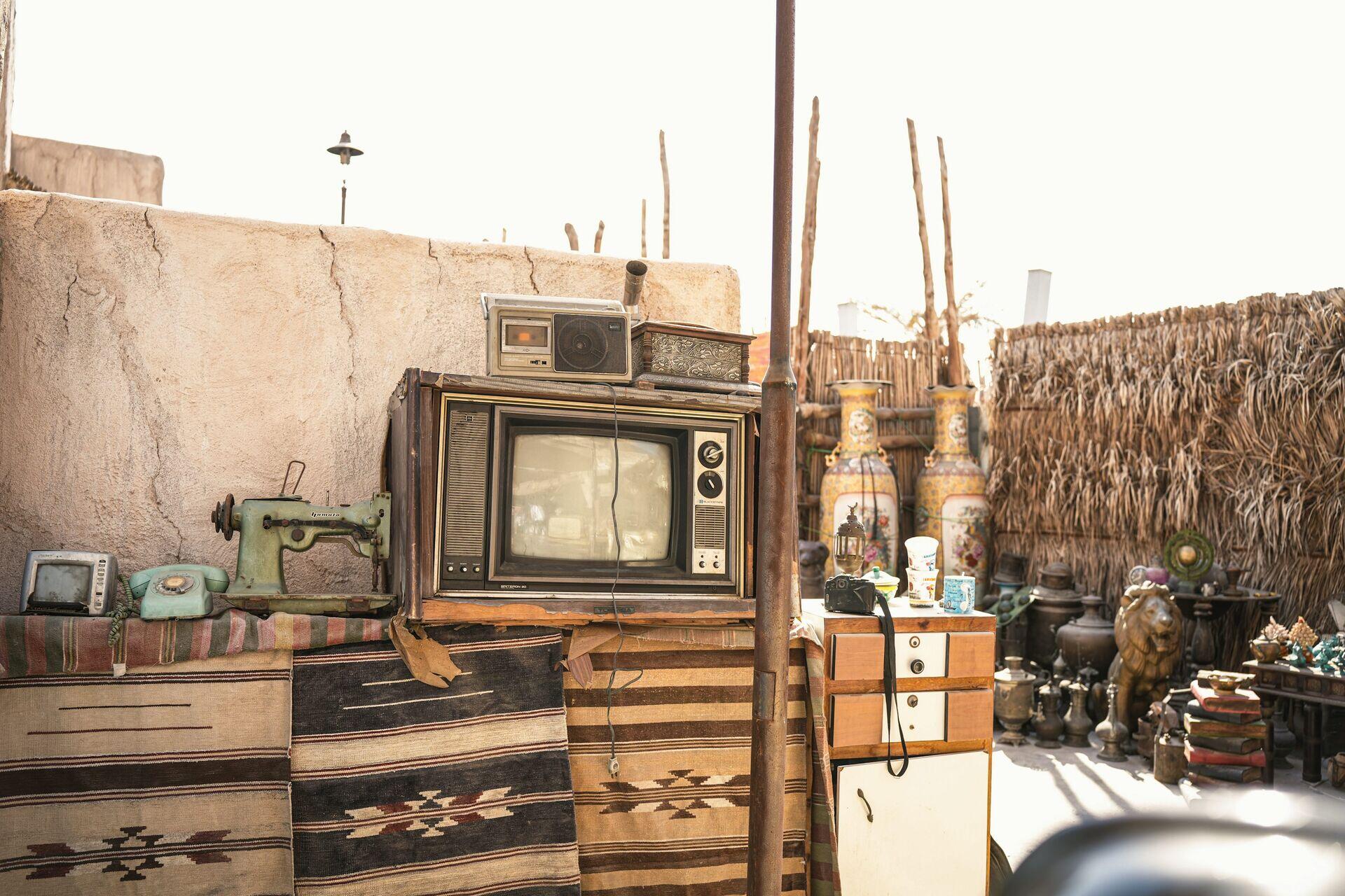 Family sitting together watching a television set inside a modest rural home at night
