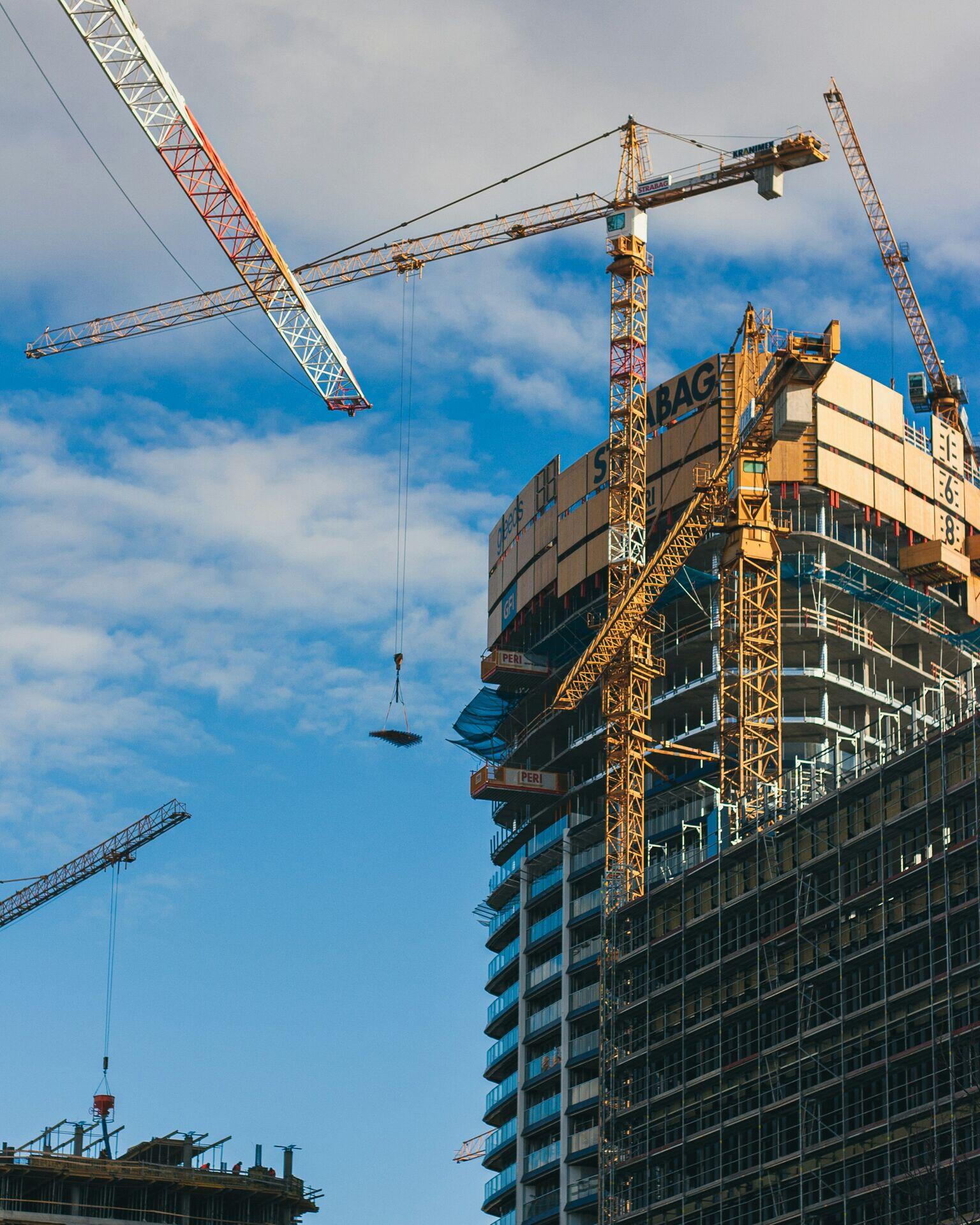 Engineer in hard hat reviewing documents at a large civil construction site