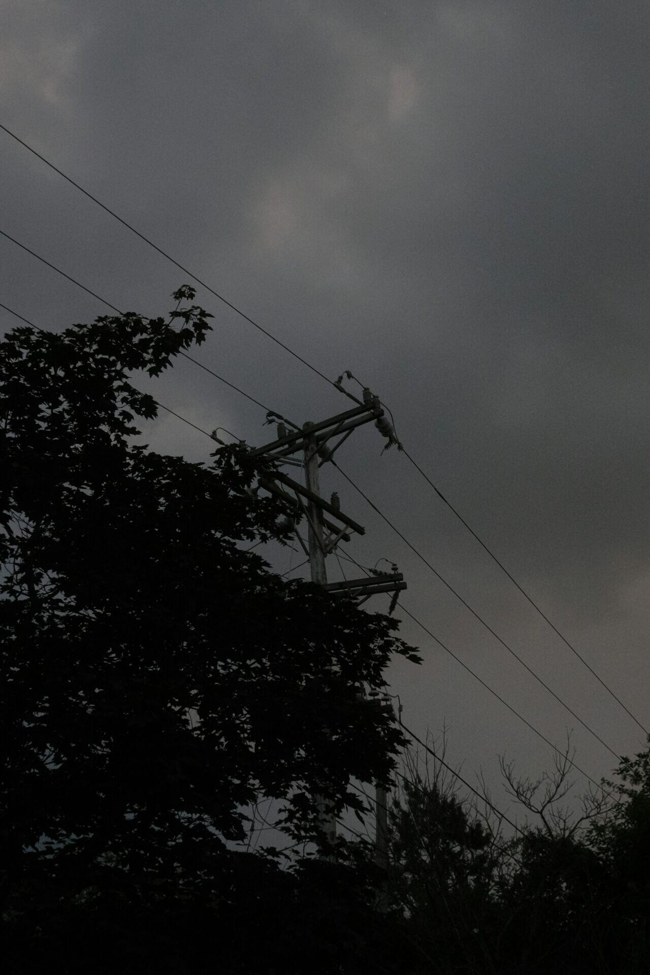 Electrical technician on a utility pole repairing power lines in a rural setting