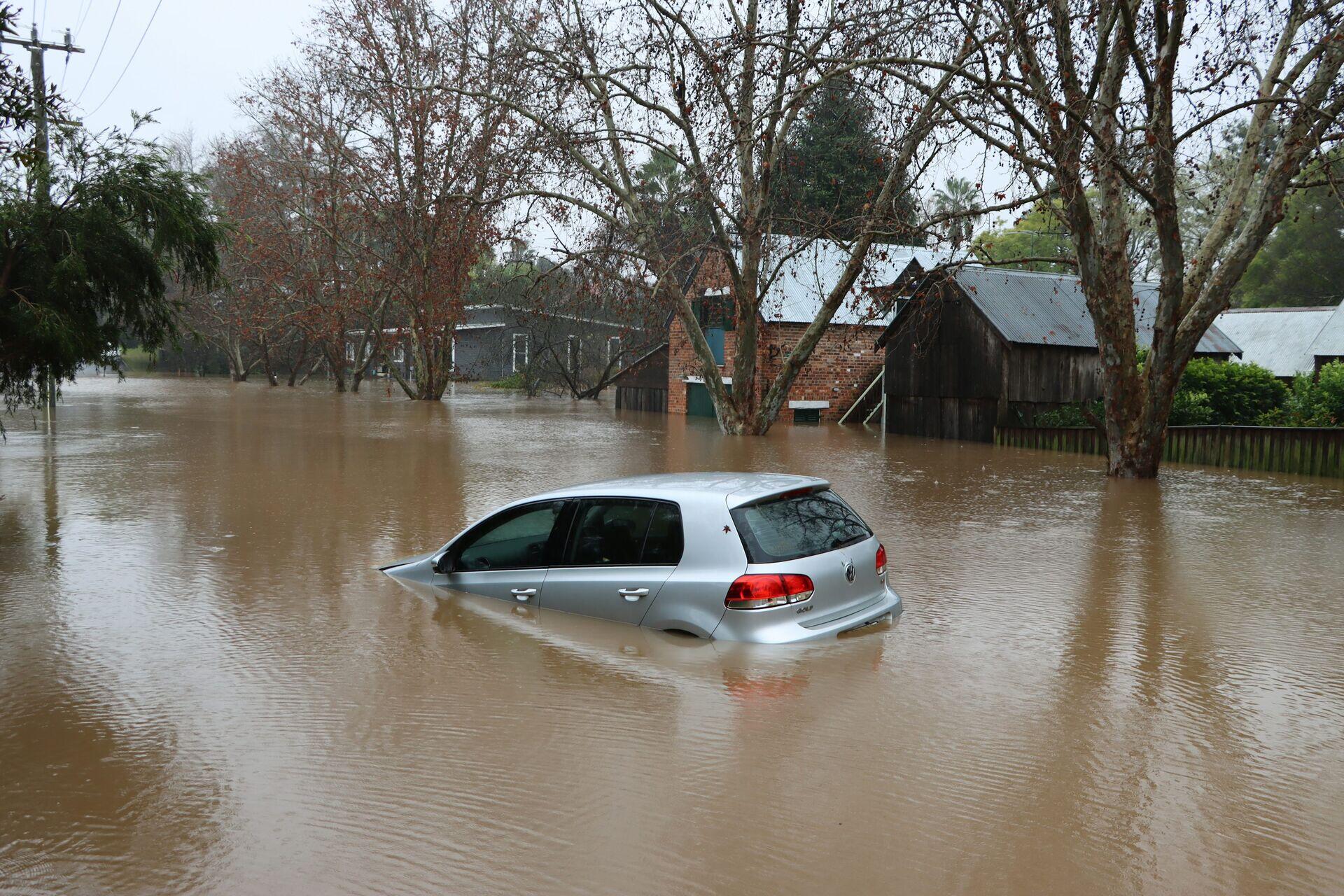 Farmer standing in waterlogged field examining damaged crops