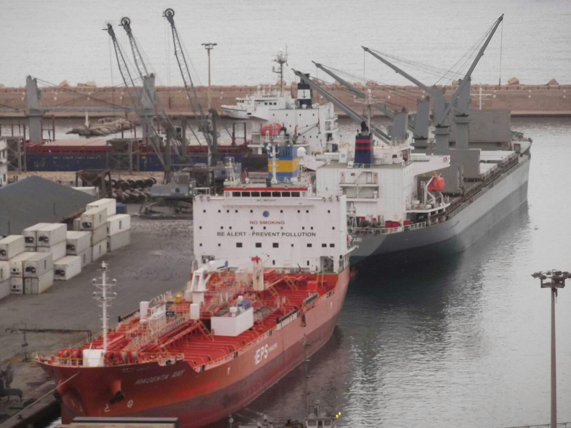 Workers unloading cargo containers at a busy West African port