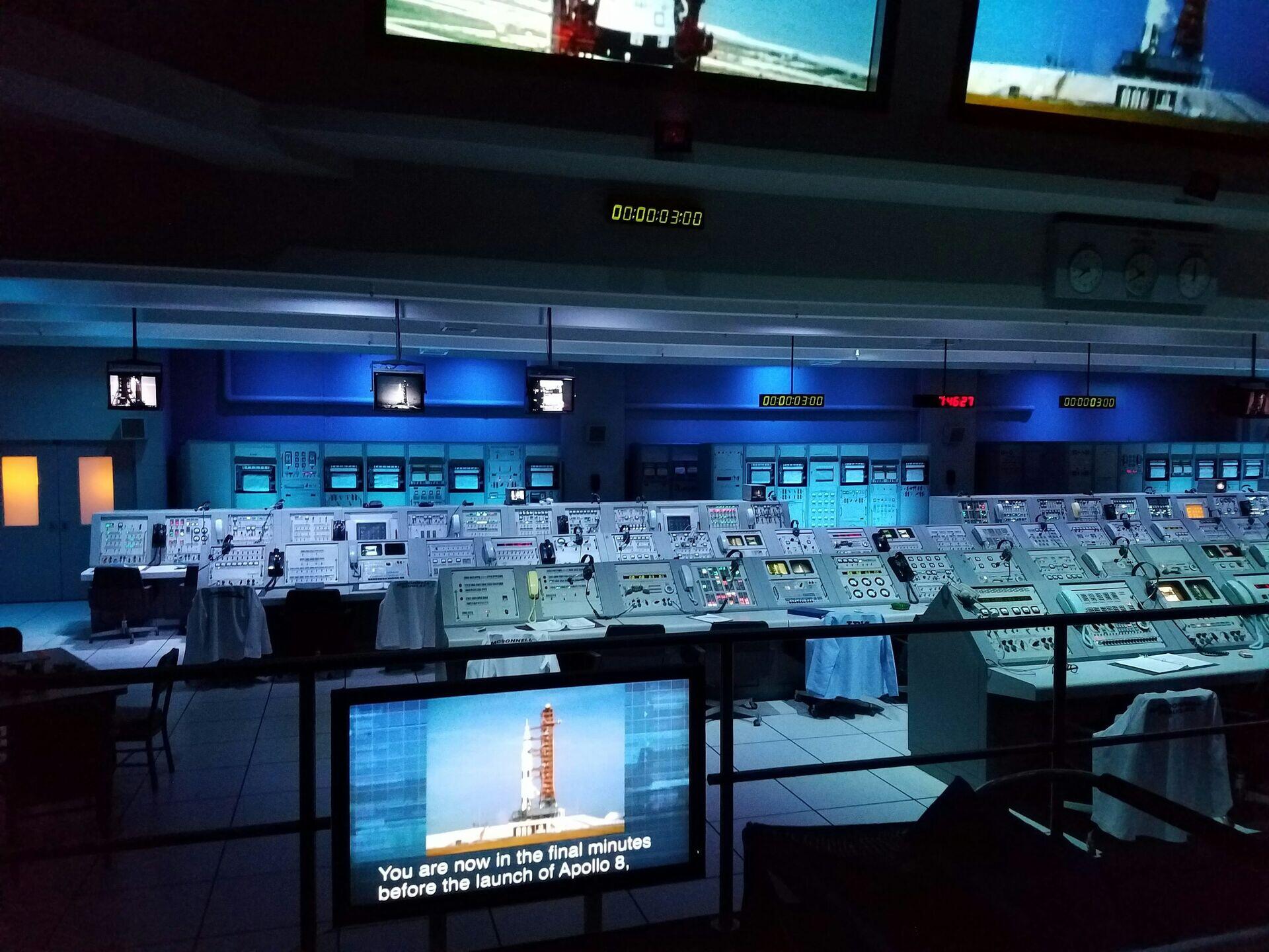 Military analysts seated at workstations with multiple screens displaying maps and data feeds in a command centre