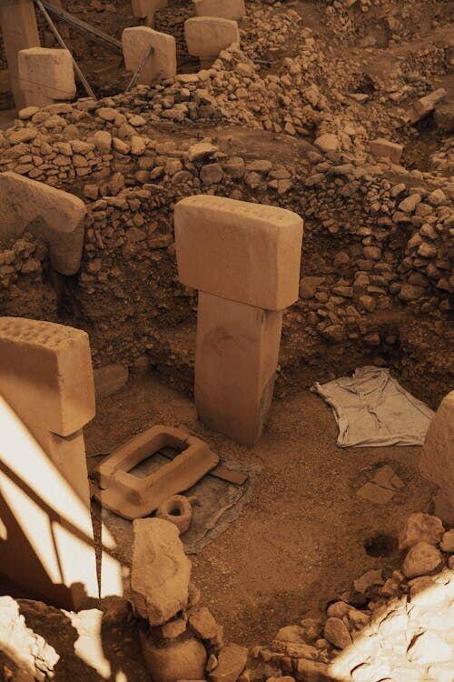 Archaeologists carefully brushing and recording artefacts at an excavation site